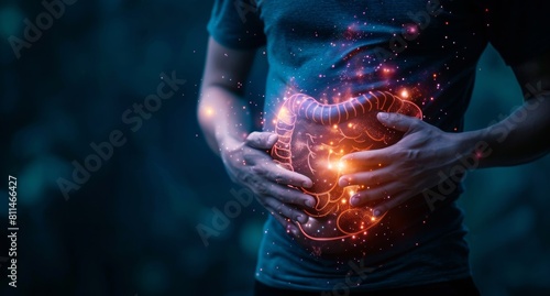 Stomach pain, indigestion concept with man holding his belly and glowing illustration of healthy anatomy organ on dark background. photo