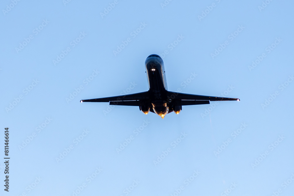 Silhouette of a Jet Plane in Flight Against a Clear Blue Sky, Engulfed in Flames