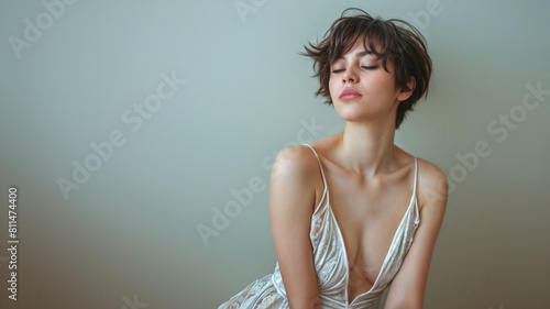 Studio portrait of a young model with short brown hair and wearing camisole lace pajamas. Copy space. photo
