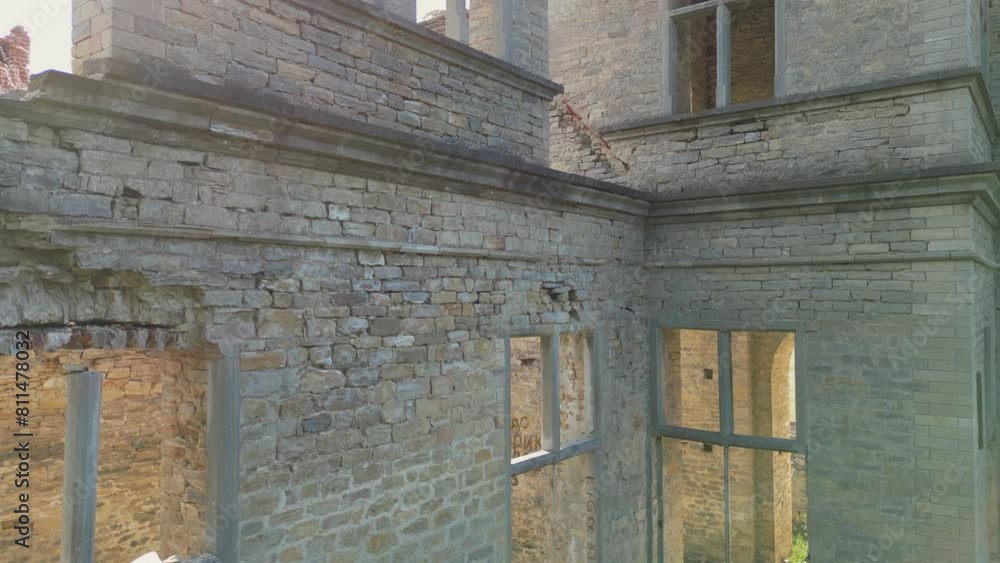 Lens flare aerial ascends walls of old brick mansion ruin in Estonia