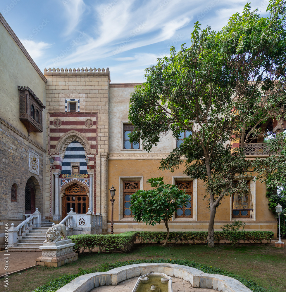 Obraz premium A serene courtyard with Mamluk style architecture surrounds a tranquil fountain under clear skies