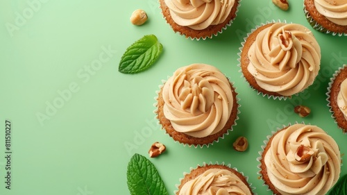 Cupcakes with hazelnut frosting and mint leaves on green background