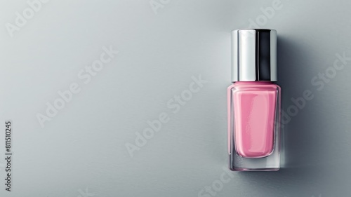 Bottle of pink nail polish against gray background