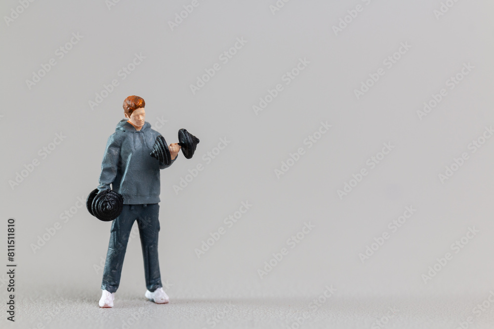 Fit Young Man Lifting Weights Against Grey Background Fit Young Man Lifting Weights Against Grey Background