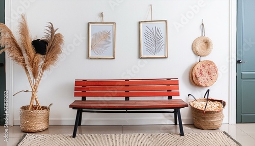 Wooden rustic bench near white wall with two frames. Farmhouse, country, boho interior desig photo