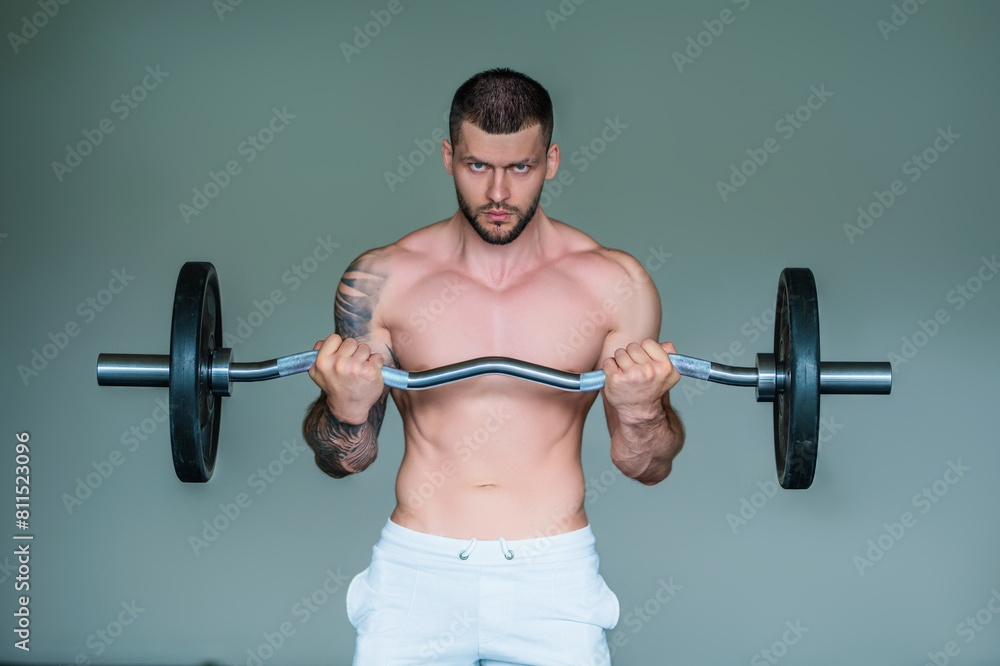 Muscular man lifting weights at gym. Handsome guy prepare to do exercises with dumbbell. Muscular man lifting weights at gym. Handsome guy prepare to do exercises with dumbbell.