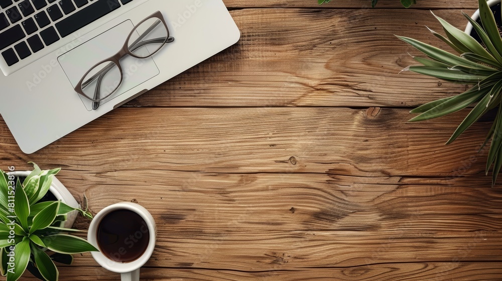 A wooden table with a laptop, glasses, coffee cup and plants on it. A wooden table with a laptop, glasses, coffee cup and plants on it.