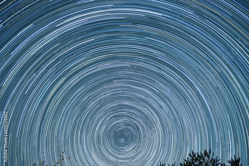 Star trail of stars moving in the night sky around the North Star. Landscape with movement of stars in the Tuscan country, time lapse	