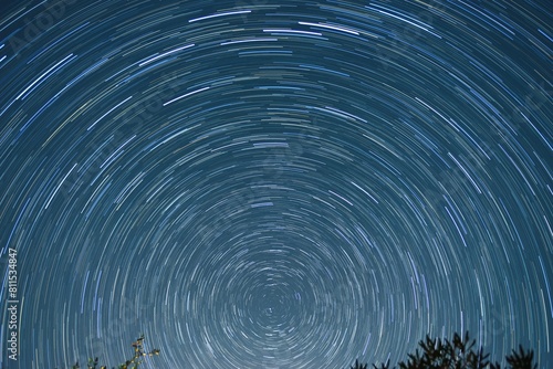 Star trail of stars moving in the night sky around the North Star. Landscape with movement of stars in the Tuscan country, time lapse	