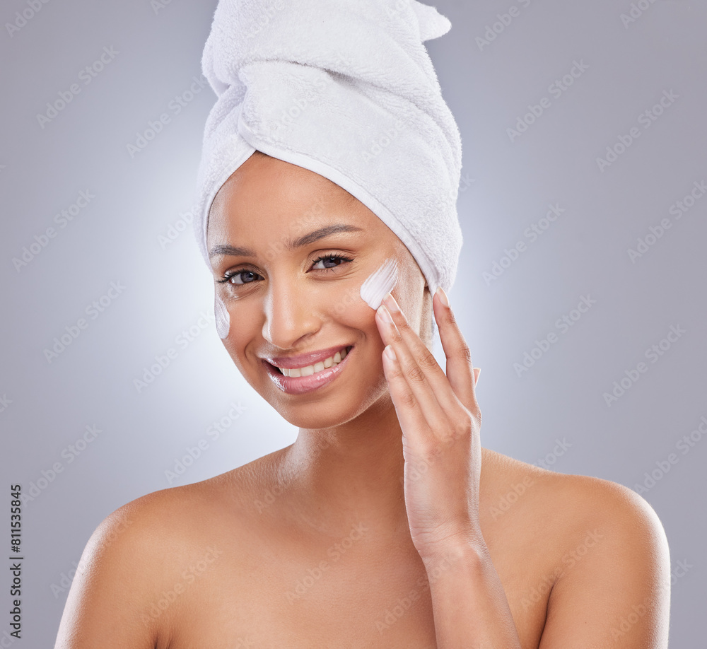 Studio, woman and towel for cream or cosmetics, moisturizer and hand on white background. Skincare, dermatology and beauty for female person, smile or portrait for lotion with glow or product on face Studio, woman and towel for cream or cosmetics, moisturizer and hand on white background. Skincare, dermatology and beauty for female person, smile or portrait for lotion with glow or product on face