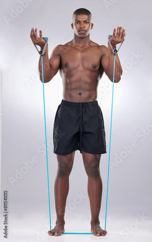 Black man, resistance band and exercise in studio portrait for wellness, progress or development by white background. Person, bodybuilder and strong in workout, fitness and training for healthy body