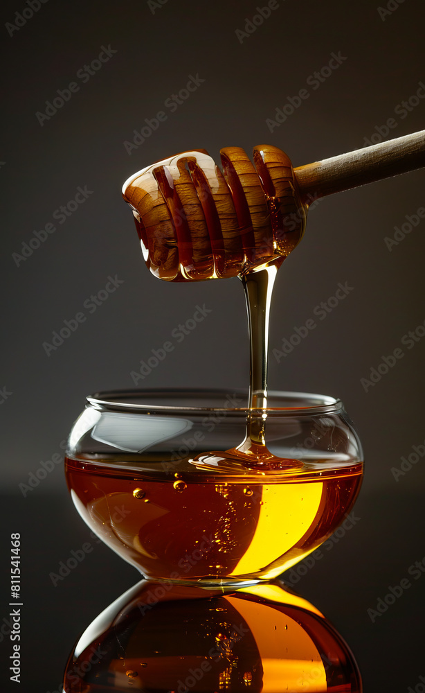 Honey in a glass bowl with a wooden stick. Honey in a glass bowl with a wooden stick.