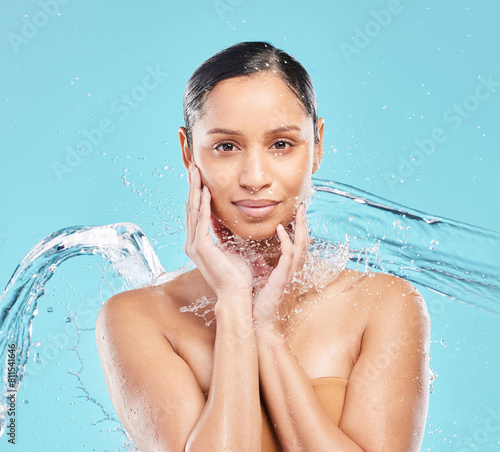 Woman  blue background or splash for skincare or wellness in portrait  cosmetic or clean and hydration  Female person  studio or dermatology with water and makeup  healthy skin or facial in bathroom