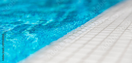 Foto Natural sunlight blur bokeh white marbles closeup of swimming pool edge and clear blue water