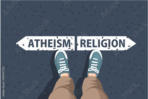 an legs in sneakers  are standing on asphalt next to arrow signs of words atheism and religion
