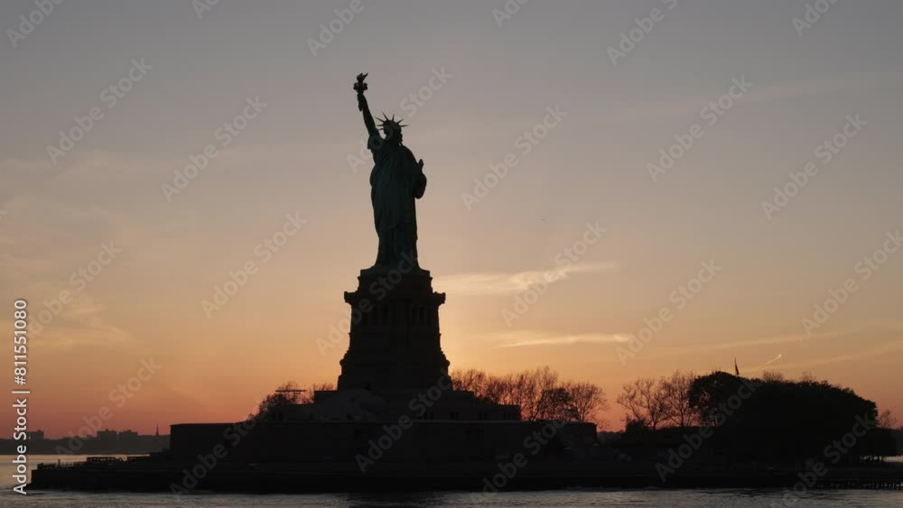 Silhouette view of the Statue of Liberty at sunset with beautiful sky in background Silhouette view of the Statue of Liberty at sunset with beautiful sky in background