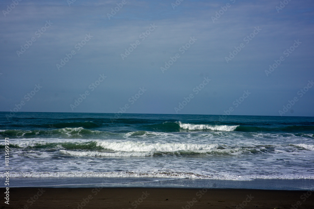 powerful foamy sea waves rolling and splashing over water surface against cloudy blue sky powerful foamy sea waves rolling and splashing over water surface against cloudy blue sky