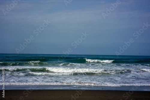 powerful foamy sea waves rolling and splashing over water surface against cloudy blue sky © Stora Space