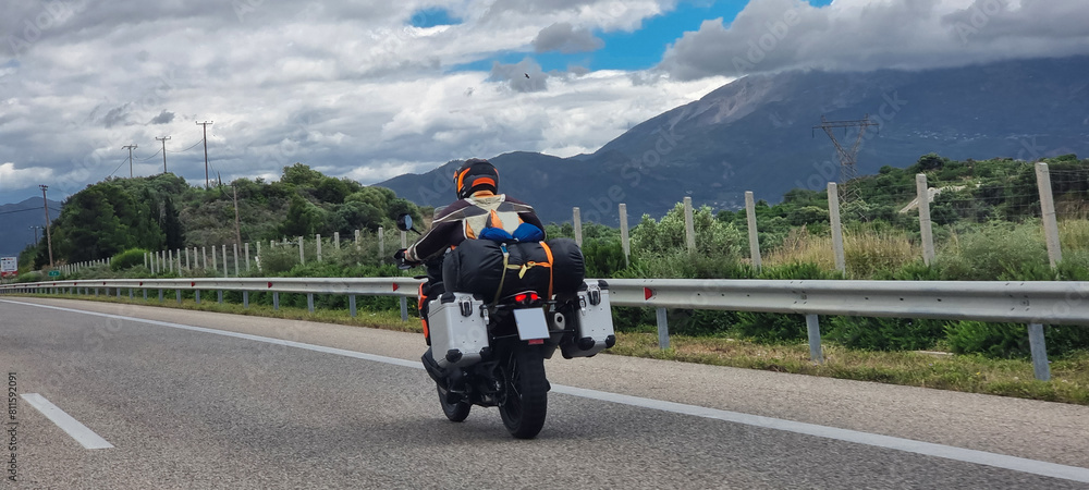 Obraz premium morobike motorbike travelling speeding on asphalt road in cloudy day in greece spring season