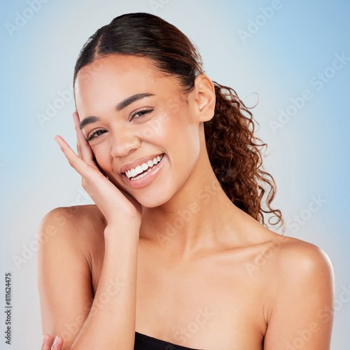 Portrait, skincare and smile of woman for beauty, shine or health isolated on blue studio background. Face, touch and model in makeup cosmetics for glow, dermatology and wellness for aesthetic in spa