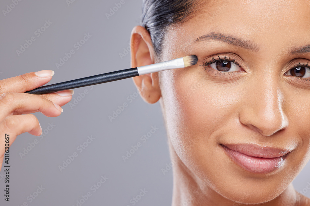 Woman, makeup and portrait in studio for eyeshadow or beauty, cosmetic or product for transformation. Female person, gray background and application for eye with brush, dermatology for wellness Woman, makeup and portrait in studio for eyeshadow or beauty, cosmetic or product for transformation. Female person, gray background and application for eye with brush, dermatology for wellness