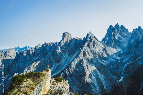 Aerial view of a man with raised hands enjoying Cadini di Misurina mountain peaks, Italian Alps, Dolomites, Italy, Europe photo