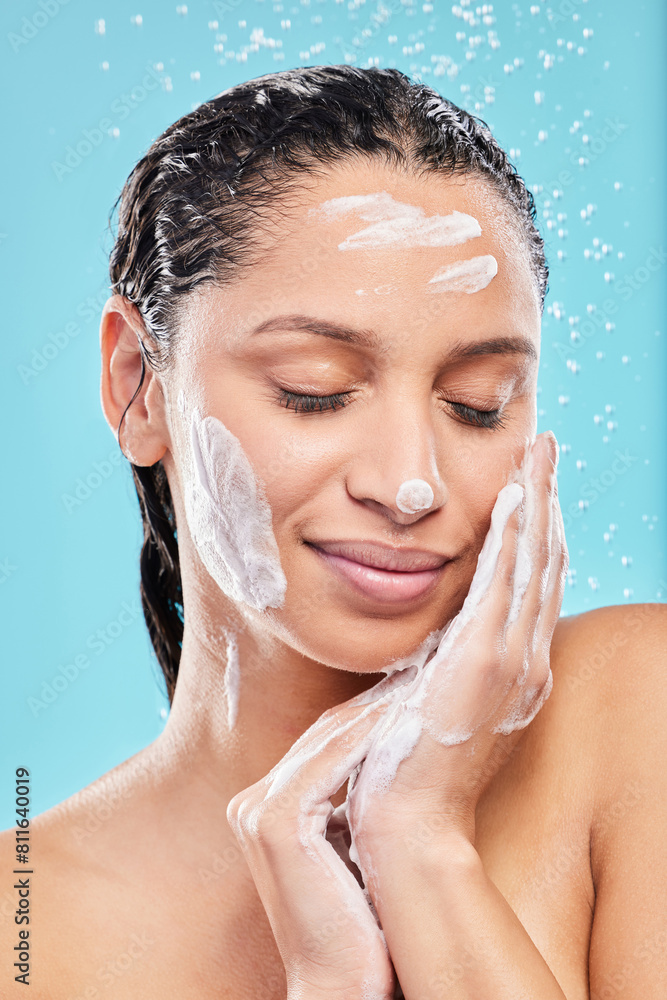 Naklejka premium Beauty, shower and woman with soap in studio for skincare, hygiene or wellness isolated on blue background. Water, foam bath and model cleaning with eyes closed for dermatology, health and wash face