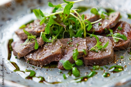 Close-up of neatly arranged beef liver slices with vibrant green herbs on a clean plate