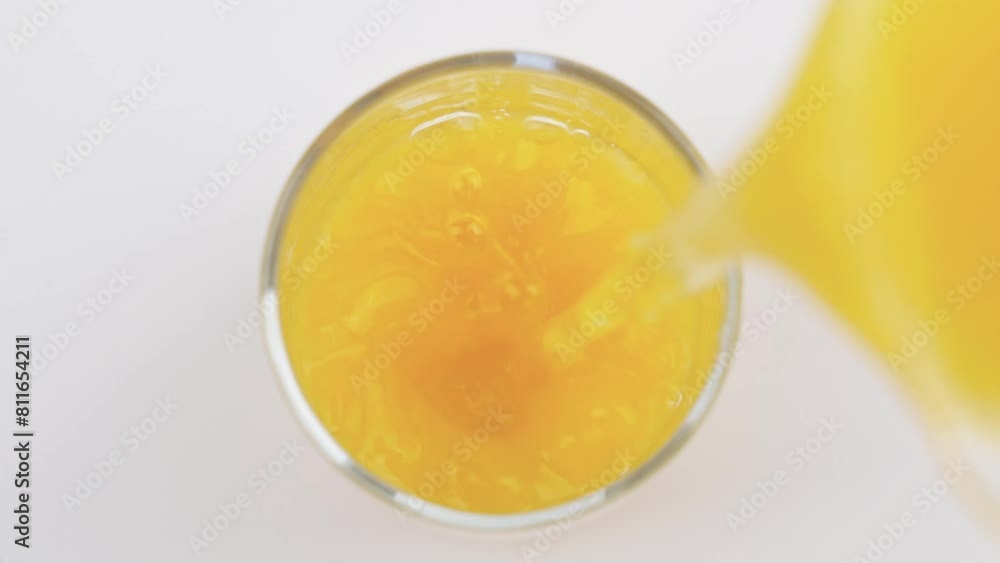 Pouring Fresh Orange Juice into Glass on white background. Pouring Fresh Orange Juice into Glass on white background.