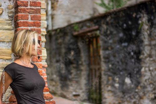 Fotografie the beautiful woman leaning in front of an old alley of the old city