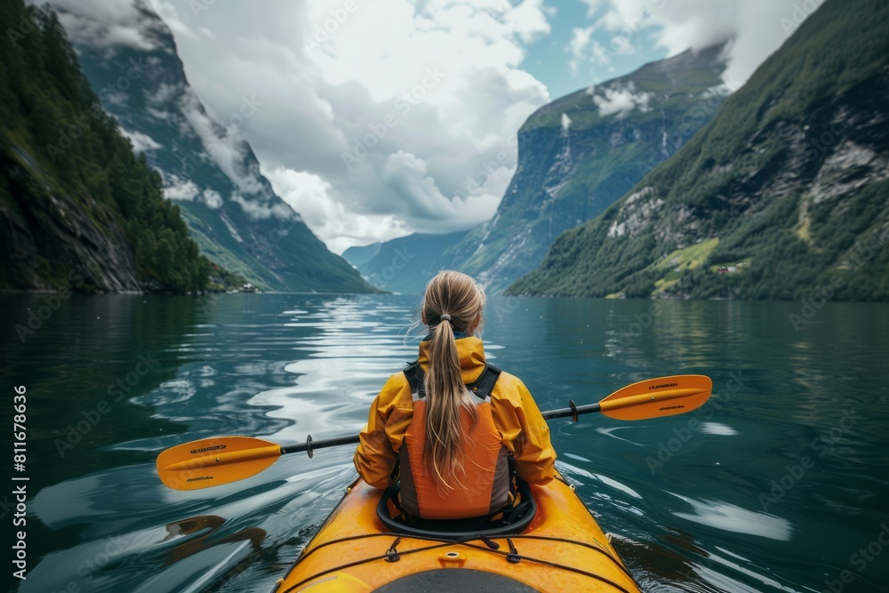 Woman in kayak floating on the water among the fjords Woman in kayak floating on the water among the fjords