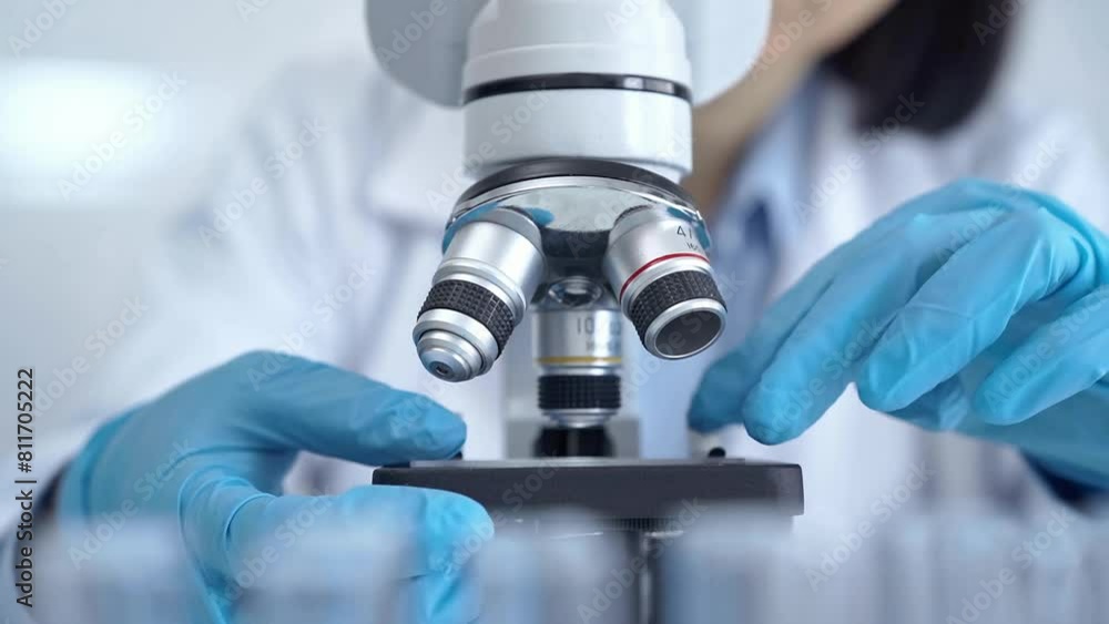 Scientist using microscope in laboratory Scientist using microscope in laboratory
