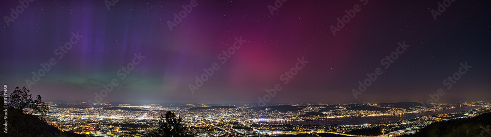 Naklejka premium Large panorama of the city of Zurich in Switzerland from Uetliberg at night with northern lights