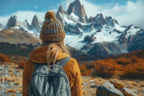 A traveler with a backpack gazes at snow-capped peaks, depicting a sense of adventure and exploration