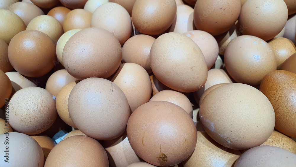 Close up of randomly stacked chicken eggs sold at the market as a background. Close up of randomly stacked chicken eggs sold at the market as a background.