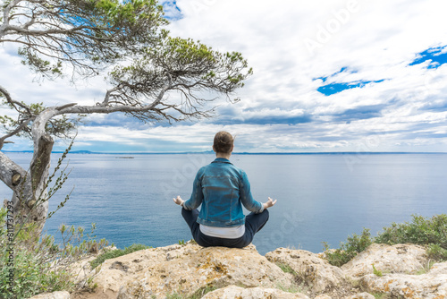Wallpaper Mural Junge Frau meditiert an einem Felsvorsprung am Meer mit Baum Torontodigital.ca