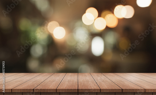 Empty wooden table top with lights bokeh on blur restaurant background.