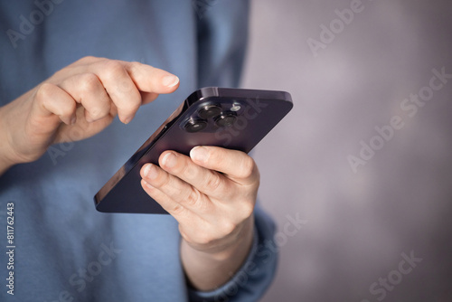 female hands pressing with finger, reading on social networks, typing text or shopping online. Mobile phone in the hands of a girl.