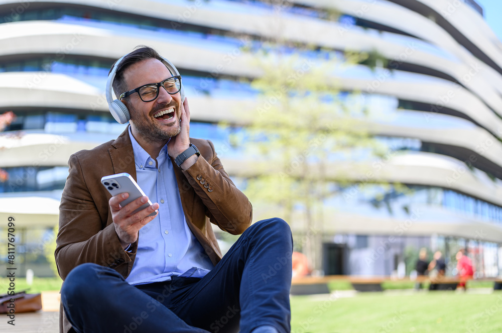 © Moon Safari - Ecstatic handsome entrepreneur with cellphone laughing and enjoying music over headphones in city © Moon Safari - Ecstatic handsome entrepreneur with cellphone laughing and enjoying music over headphones in city