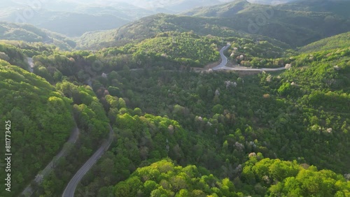 Mountain road seen from a drone. High angle fotoage of vehicles traversing a picturesque mountain curve of Shipka pass in Bulgaria. A busy European forrest road seen from above. Cars trucks driving
 photo