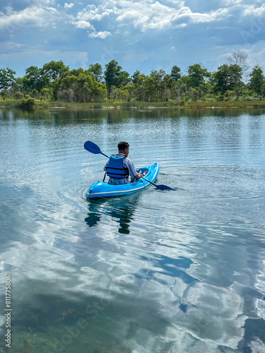 Asian young man using a canoe on Lake Seran in Banjarbaru, South Kalimantan