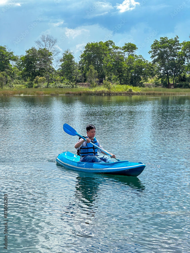 Asian young man using a canoe on Lake Seran in Banjarbaru, South Kalimantan Asian young man using a canoe on Lake Seran in Banjarbaru, South Kalimantan