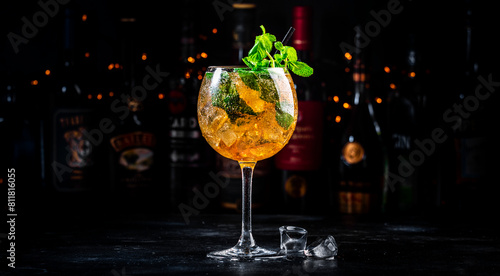 Summer refreshing cocktail drink with cognac, liqueur, sparkling wine with ice and mint in wine glass, dark background © 5ph