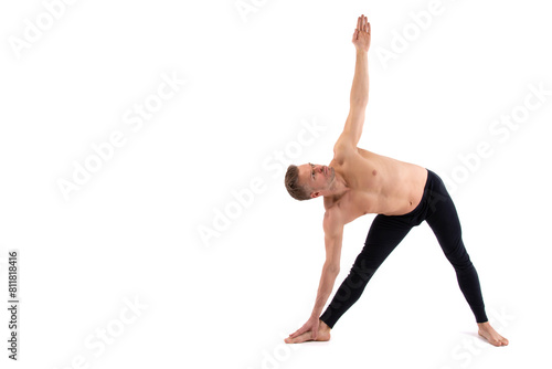 Sports and healthy lifestyle. An attractive man is doing yoga and pilates. White background.
