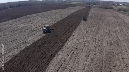 tractors plows the field before sowing seeds on a spring sunny day
