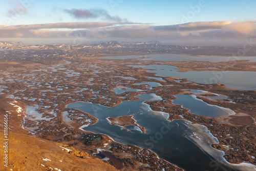 Winter frozen lakes on swamps on mountain hills under cloudy sunset. Iceland, north-eastern region. photo