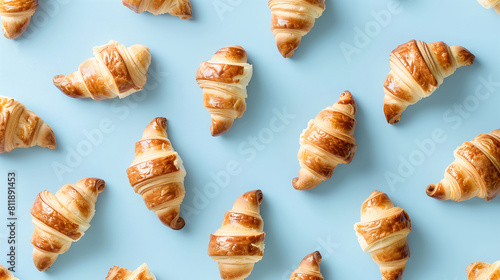 Neatly Arranged Golden Croissants on a Cool Blue Background