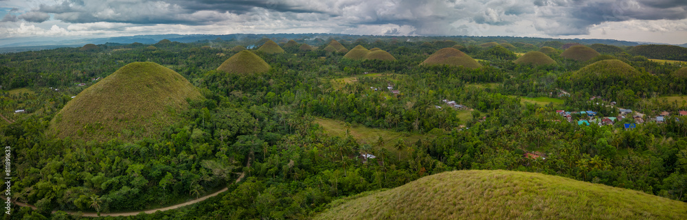 A panoramic view of the famous Chocolate Hills in Bohol, Philippines, showcasing the natural cone-shaped geological formations amidst lush vegetation A panoramic view of the famous Chocolate Hills in Bohol, Philippines, showcasing the natural cone-shaped geological formations amidst lush vegetation