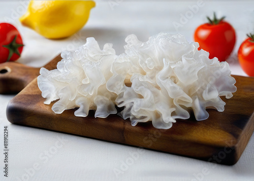 Tremella fuciformis mushroom on a wooden cutting board. Chinese gelatinous fungi. Snow fungus.	