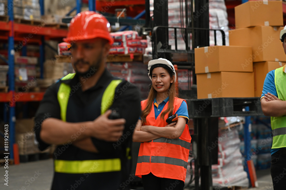 Confident worker standing arms crossed in distribution warehouse, Selective focus Confident worker standing arms crossed in distribution warehouse, Selective focus